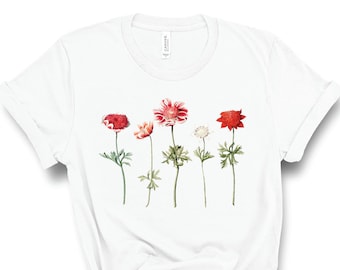 May include: White t-shirt with a floral design featuring five red, pink, and white flowers with green stems and leaves.