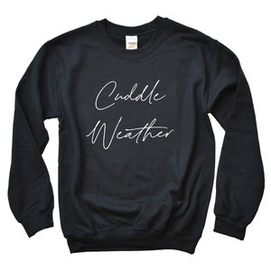 May include: Black sweatshirt with the text "Cuddle Weather" written in white cursive.