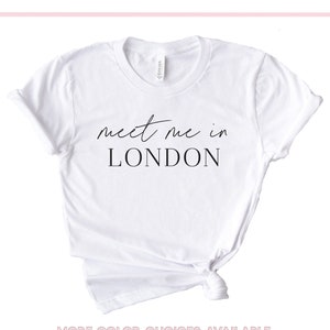 May include: White t-shirt with the text "meet me in LONDON" printed in black.