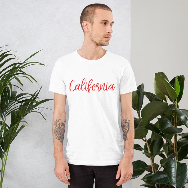 May include: White t-shirt with the word "California" written in red cursive lettering.
