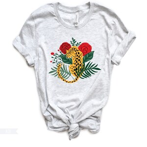May include: A gray t-shirt with a graphic of a leopard sitting in a jungle scene with red roses and green leaves.
