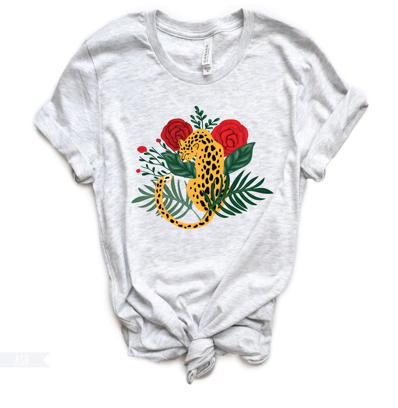 May include: A gray t-shirt with a graphic of a leopard sitting in a jungle scene with red roses and green leaves.