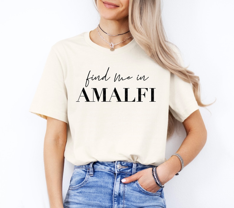 May include: A white t-shirt with black text that reads "find me in AMALFI".