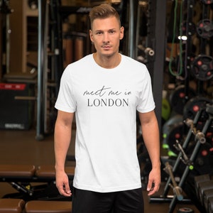 May include: White t-shirt with black text that reads "meet me in LONDON" in a cursive font.