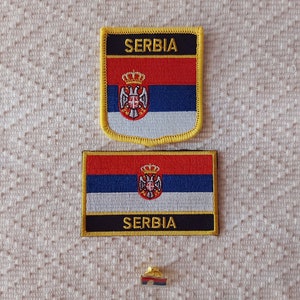 Op de afbeelding: Twee geborduurde patches met de Servische vlag en het woord "SERBIË" in zwarte letters. Een kleine gouden speld met de Servische vlag is ook afgebeeld.