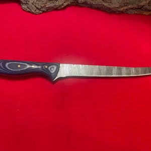 May include: A blue and black handled knife with a long, thin blade. The blade is made of stainless steel and has a hammered finish.