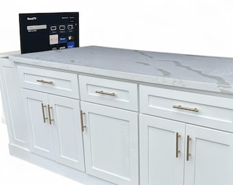 White kitchen island with TV lift-up cabinet and quartz top