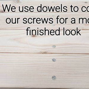 May include: Close-up of light-colored wooden planks with visible wood grain. The text reads, "We use dowels to cover our screws for a more finished look." Several screws are visible, covered with dowels.
