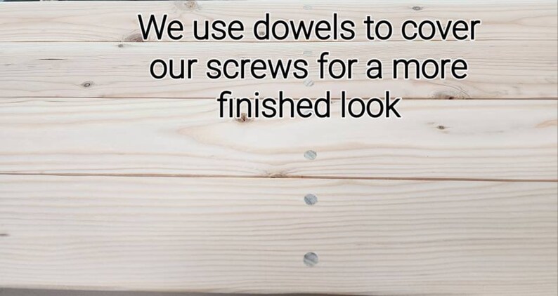 May include: Close-up of a light wood surface with three dowels covering screw holes. The text "We use dowels to cover our screws for a more finished look" is visible at the top of the image.