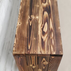 May include: A rustic wooden box with a dark brown finish. The box is made of reclaimed wood and has a natural wood grain pattern. The box is perfect for storing small items or displaying decorative items.