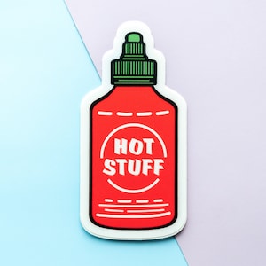 May include: A red and white hot sauce bottle sticker with a green lid and the text "HOT STUFF" in a white circle.