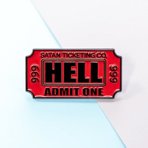 Puede incluir: Pin de esmalte rojo y negro con forma de ticket con el texto "SATAN TICKETING CO. 666 999 HELL ADMIT ONE 666".