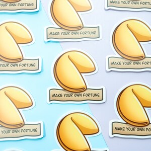 May include: Nine fortune cookie stickers with the text "Make your own fortune" on each. The stickers are on a light blue and purple background.