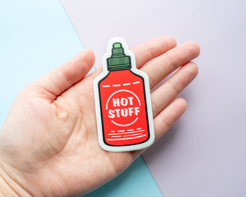 May include: A red and white sticker of a hot sauce bottle with the text "HOT STUFF" in a circle on the label.