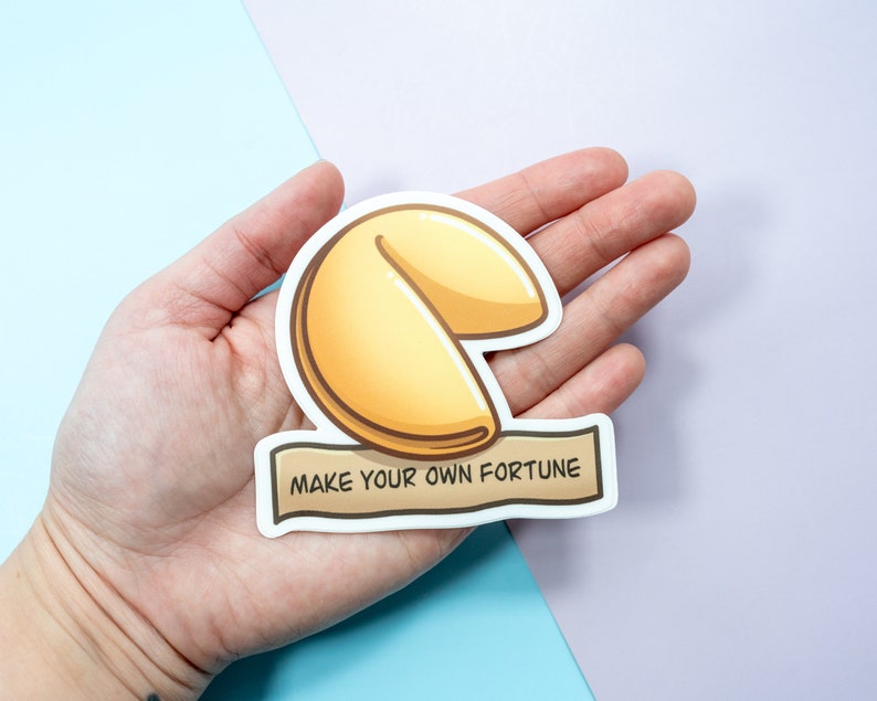 May include: A white sticker with a cartoon illustration of a fortune cookie and the text "Make your own fortune".
