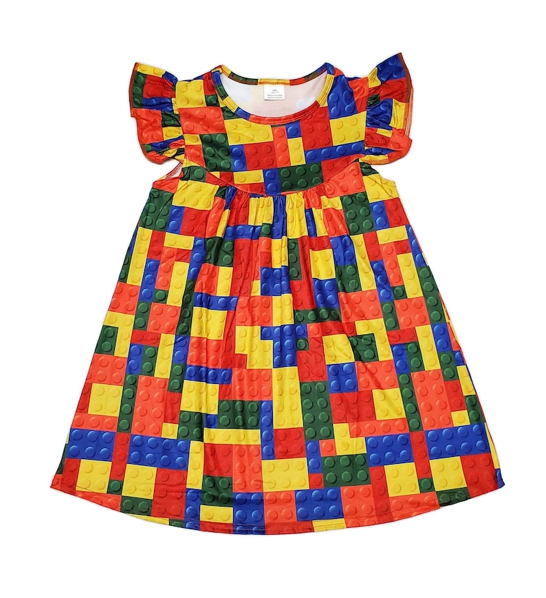 May include: A colourful dress for girls with a pattern of red, yellow, blue and green building blocks. The dress has a round neckline and short, ruffled sleeves.