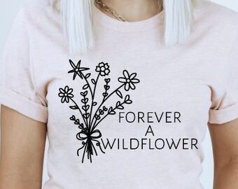 May include: A pink t-shirt with a black graphic of a bouquet of flowers and the text "FOREVER A WILDFLOWER".