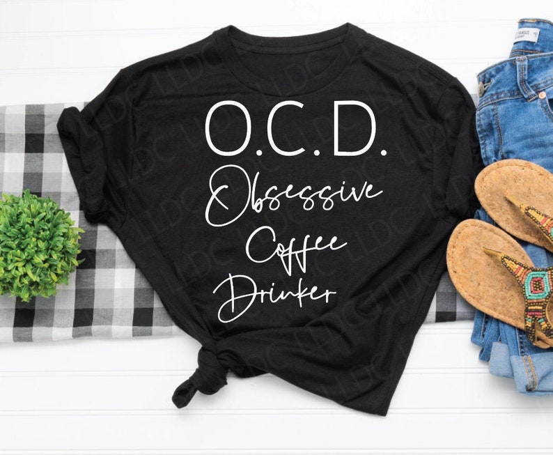 May include: Black t-shirt with white text that reads "O.C.D. Obsessive Coffee Drinker".