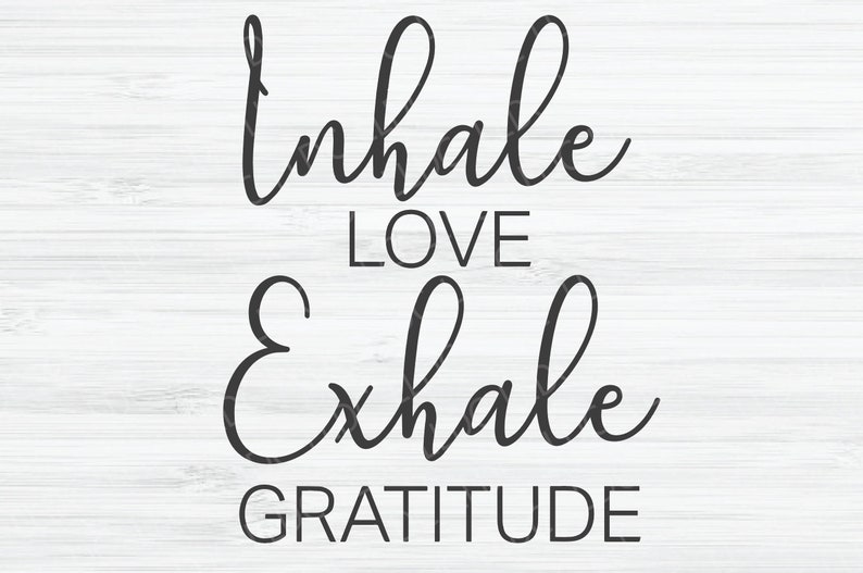 May include: Black and white typography on a white wood background. The text reads "Inhale Love Exhale Gratitude".