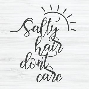 May include: Black and white calligraphy text on a white wood background. The text reads "Salty hair don't care" with a sun graphic above the word "Salty".