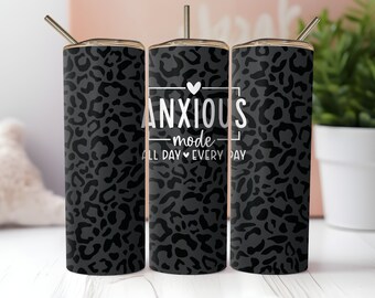 May include: Three black and white leopard print tumblers with a white graphic that reads "ANXIOUS -mode- ALL DAY EVERY DAY".