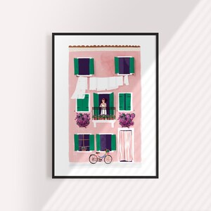 May include: A pink building with green shutters and a balcony. There are flowers in pots on the balcony and a bicycle parked in front of the building.