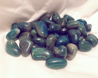 May include: A pile of smooth, green and gray agate tumbled stones. The stones are various sizes and shapes, and have a polished, shiny finish.
