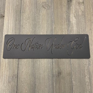 May include: Black metal sign with the text "One Nation Under God" in a cursive font.