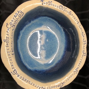 May include: A white ceramic bowl with a blue glaze and a blue inscription around the rim. The inscription reads "The Fruit of the Spirit is Love, Joy, Peace, Longsuffering, Gentleness, Goodness, Faith, Meekness, Temperance. Self-Control. Galatians 5:22-23."