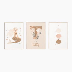 Könnte beinhalten: Drei gerahmte Drucke mit einer Meerjungfrau, dem Buchstaben T und Muscheln. Der Buchstabe T ist mit Muscheln und Seetang verziert. Der Druck mit dem Buchstaben T enthält auch den Text "T is for Tully".