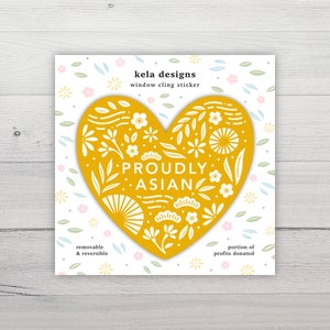 May include: A yellow heart-shaped window cling sticker with white floral designs and the text "PROUDLY ASIAN".