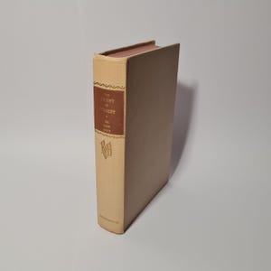 May include: A hardback book titled "The Ascent of Everest" by John Hunt. The book has a beige cover with a brown title block and gold lettering. The spine features a decorative pattern and the publisher's logo.