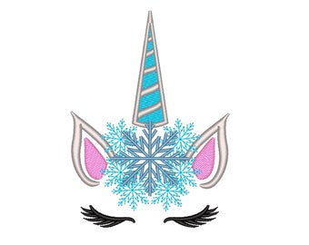 Op de afbeelding: Geborduurd eenhoornsgezicht met een zilveren hoorn, lichtblauwe accenten en een sneeuwvlokontwerp. De oren zijn wit met roze binnendetails en de ogen hebben lange zwarte wimpers. Een grillig ontwerp.
