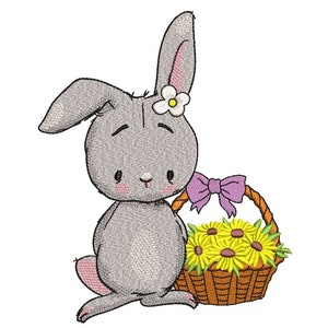 Könnte beinhalten: Ein graues Kaninchen mit einer weißen Blume auf dem Kopf hält einen braunen Weidenkorb voller gelber Blumen. Das Kaninchen hat eine rosa Nase und eine lila Schleife am Korb.
