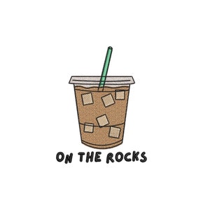 May include: A brown and white illustration of a cup of iced coffee with a green straw and the text "ON THE ROCKS".