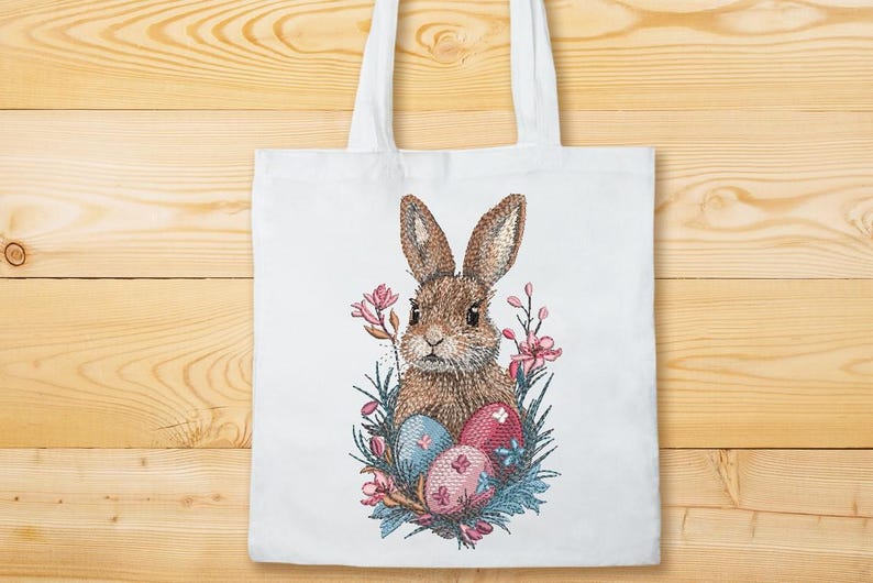 May include: A white tote bag with a brown bunny rabbit surrounded by pink flowers and blue and pink Easter eggs.