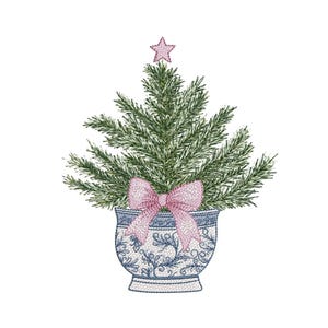 Puede incluir: Diseño bordado de un árbol de Navidad. El árbol es verde con una estrella rosa en la parte superior y un lazo rosa. Se encuentra en una maceta con estampado azul y blanco. El diseño está sobre un fondo blanco.