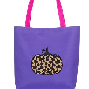 May include: Purple tote bag with pink handles and a black embroidered leopard print pumpkin.