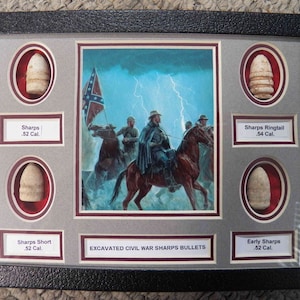 May include: A framed display of five excavated Civil War Sharps bullets, each bullet is displayed in a separate oval-shaped frame with a label identifying the type of bullet and its caliber. The background of the display is a painting of Confederate soldiers on horseback riding through a stormy landscape. The text "EXCAVATED CIVIL WAR SHARPS BULLETS" is printed below the painting.