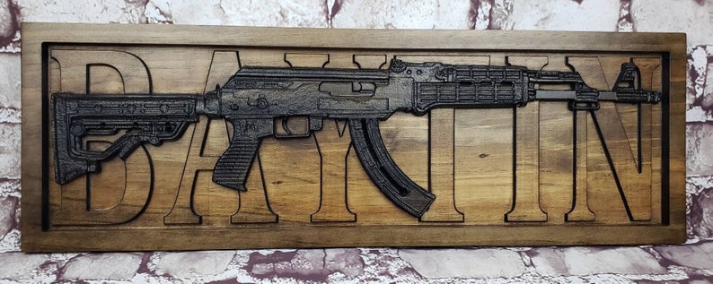 May include: A wooden sign with a carved image of a rifle and the name "DAYTON" in large letters.