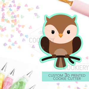 May include: A brown and white owl cookie cutter with a branch. The cutter is 3D printed and is a custom design. The text "CUSTOM 3D PRINTED COOKIE CUTTER" is on a light blue background.
