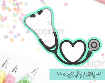 May include: A teal blue 3D printed cookie cutter shaped like a stethoscope with a heart. The cookie cutter is on a white background with pink and white heart sprinkles. The text "CUSTOM 3D PRINTED COOKIE CUTTER" is on a teal blue background.