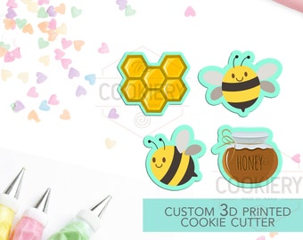 May include: A set of four 3D printed cookie cutters featuring a honeycomb, a bee, a bee with wings spread, and a honey jar. The cutters are yellow, black, and brown. The text "CUSTOM 3D PRINTED COOKIE CUTTER" is printed on a turquoise background.