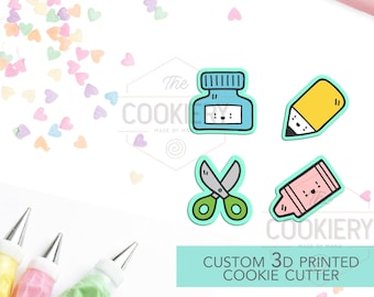 May include: A collection of custom 3D printed cookie cutters in the shapes of school supplies, including a pencil, scissors, ink bottle, and crayon. The image also features pastry bags, a rolling pin, and heart-shaped sprinkles.