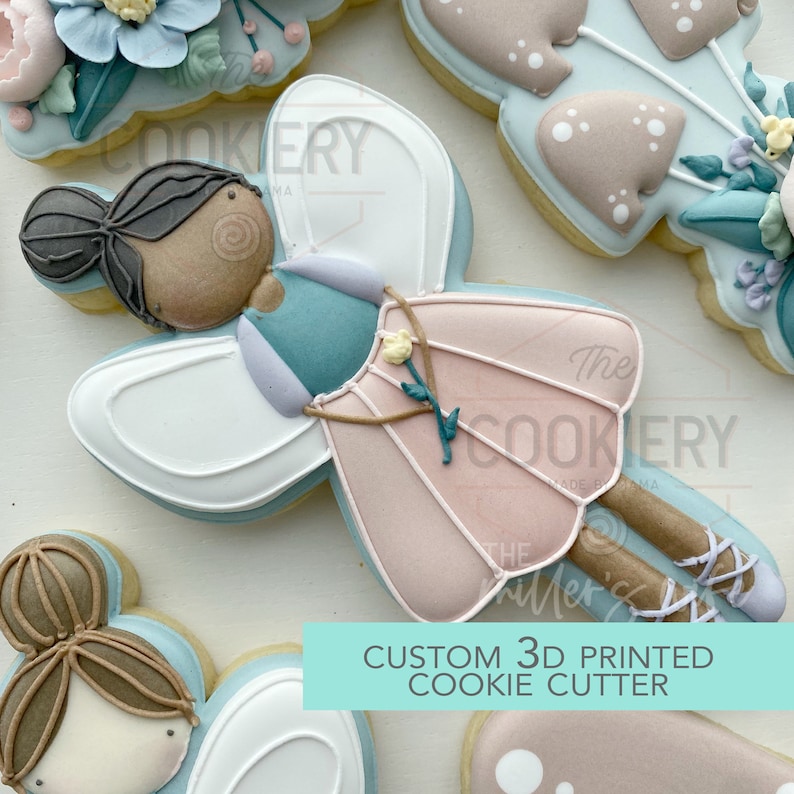 May include: A 3D printed cookie cutter in the shape of a fairy with brown hair, a pink dress, white wings, and brown legs. The text "CUSTOM 3D PRINTED COOKIE CUTTER" is printed on a turquoise background.