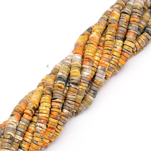 May include: A strand of yellow, gray, and orange gemstone beads. The beads are round and have a speckled pattern.