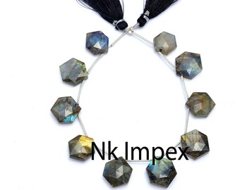 May include: A strand of 10 faceted labradorite gemstone beads with a silver wire strung through them. The beads are a dark gray with iridescent blue and green flashes. The strand is finished with black tassels on each end.