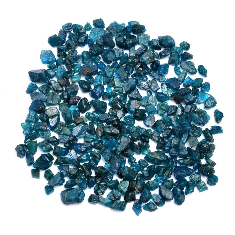 May include: A large collection of blue apatite rough stones. The stones are various sizes and shapes, and have a deep blue color.