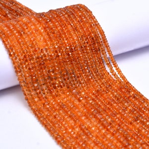 May include: A strand of orange gemstone beads. The beads are faceted and have a slightly irregular shape. The beads are strung on a clear thread and are ready to be used for jewelry making.