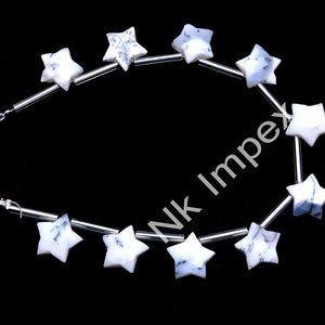 May include: A strand of white star-shaped beads with blue and grey marbling. The beads are strung on silver wire.